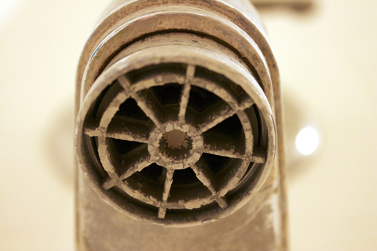 Thick white limescale and calcium deposits encrusting a tap from hard water